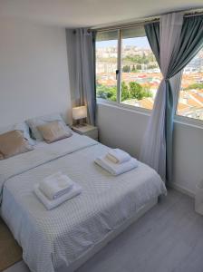 a bedroom with a bed with two towels on it at Vista Panorâmica Amadora in Amadora