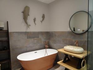a bathroom with a bath tub and a mirror at Chambres d'hotes - B&B Soulac 23 in Soulac-sur-Mer