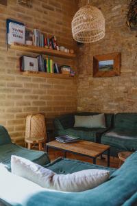 a living room with couches and a table and books at ECOTurisme Can Buch HOTEL in Sant Aniol de Finestras