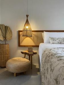 - une chambre avec un lit, un tabouret et une lampe dans l'établissement Taiba Desert Point, à Taíba