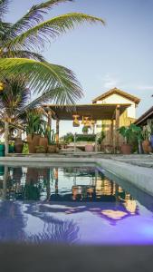 une piscine avec un palmier et une maison dans l'établissement Taiba Desert Point, à Taíba