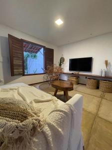 a living room with a bed and a flat screen tv at Taiba Desert Point in Taíba