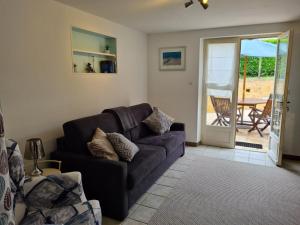 ein Wohnzimmer mit einem Sofa und einer Terrasse in der Unterkunft Le Malpas Woodpecker in Belvès
