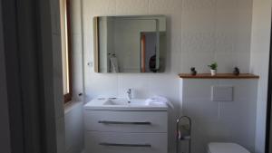 a bathroom with a sink and a mirror and a toilet at Au Pont de la Ginéze in Barjac
