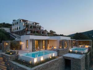 una casa con piscina y un edificio en Casa Di Fiori Andros Suites, en Ándros
