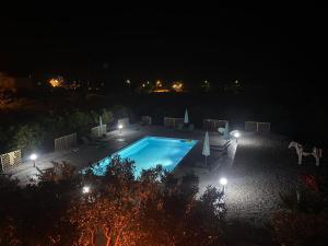 an empty swimming pool at night with lights at Ktima Klimentini in Vivari