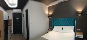 a bedroom with a white bed and a blue headboard at Katerina's Resort in Sarti