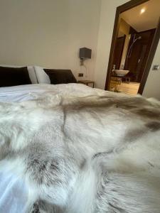 um cobertor em cima de uma cama num quarto em HOLA ANDORRA - family apartment em Bordes d´Envalira 