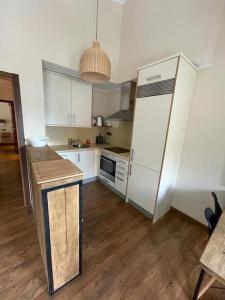 uma cozinha com um frigorífico branco e piso em madeira em HOLA ANDORRA - family apartment em Bordes d´Envalira 