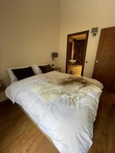 a white bed in a bedroom with a wooden floor at HOLA ANDORRA - family apartment in Bordes d´Envalira