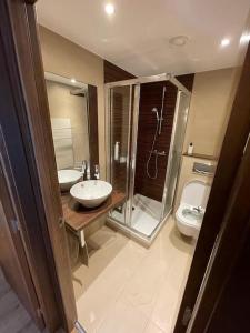 a bathroom with two sinks and a shower and a toilet at HOLA ANDORRA - family apartment in Bordes d´Envalira