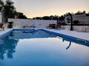 a swimming pool with blue water in a backyard at Apartments T&M in Vinišće