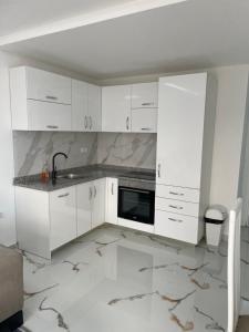 a white kitchen with white cabinets and a sink at Draga in Ulcinj