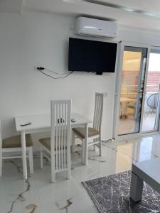a living room with a table and a tv on the wall at Draga in Ulcinj