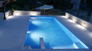 een zwembad met verlichting in de achtertuin bij Apartments T&M in Vinišće