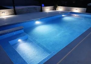 a swimming pool lit up at night with lights at Apartments T&M in Vinišće +38 photos