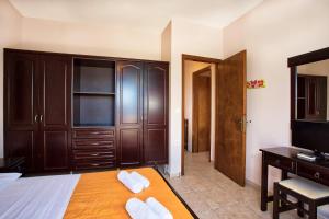 een slaapkamer met een bed, een bureau en een televisie bij Villa Κτήμα Νικόλα in Likórrevma