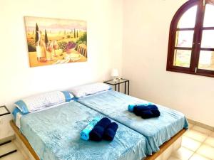 a bedroom with a bed with two blue pillows on it at Casa Delfin in Corralejo