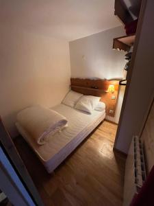 ein kleines Schlafzimmer mit einem Bett in einem Zimmer in der Unterkunft Chamrousse Appart 8 personnes au pied des pistes in Chamrousse