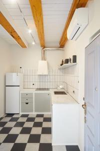 eine Küche mit weißen Geräten und einem karierten Boden in der Unterkunft Incantevole appartamento in darsena in Mailand