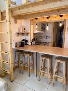 a kitchen with a large wooden counter and stools at Proche de la vieille ville et des plages, et parking GRATUIT ! in Antibes