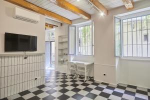 Zimmer mit einem Tisch, einem TV und Fenstern in der Unterkunft Incantevole appartamento in darsena in Mailand