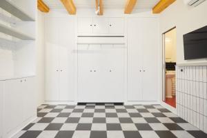 eine Küche mit weißen Schränken und einem karierten Boden in der Unterkunft Incantevole appartamento in darsena in Mailand