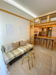 a living room with a couch and a kitchen at Proche de la vieille ville et des plages, et parking GRATUIT ! in Antibes