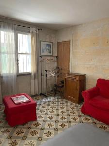een woonkamer met een rode bank en een tafel bij Appart' Cosy Beaucairois in Beaucaire