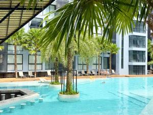 una gran piscina con una palmera frente a un edificio en 5 Stars Kamala Beach Resort D49, en Kamala Beach
