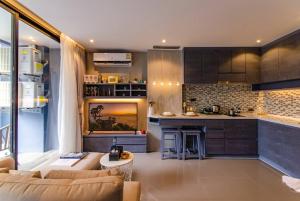 een woonkamer met een bank en een keuken bij 5 Stars Kamala Beach Resort D49 in Kamala Beach