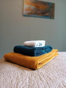 a stack of towels sitting on top of a bed at Lovely Stay in Siauliai in Šiauliai