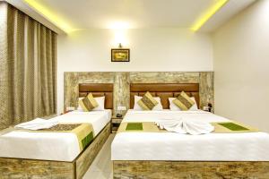 2 bedden in een hotelkamer met witte muren bij Gracious by Vishesh Hotels & Home Stay in New Delhi