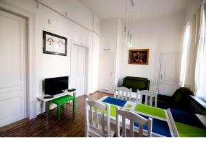 a living room with a table and chairs and a television at CentrÁlom Apartman in Pécs