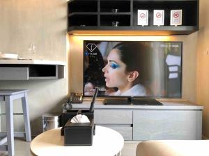 a room with a television with a woman on it at 5 Stars Kamala Beach Resort D49 in Kamala Beach