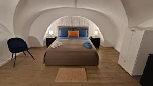 een slaapkamer met een bed en een stoel in een kamer bij MAISON VENTIMIGLIA 83 in Catania