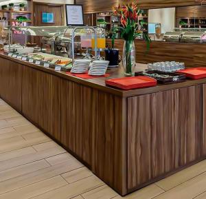 a restaurant counter with red napkins and dishes on it at Flat Hotel S4 - Aguas Claras in Brasília