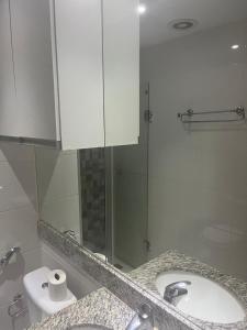 a bathroom with a sink and a glass shower at Flat Aguas Claras 218 S4 in Brasília