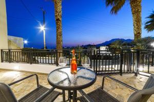 stół z 2 kieliszkami do wina na balkonie w obiekcie Palm home 1 w mieście Makry Gialos