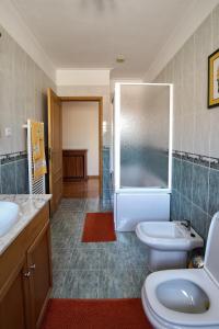 a bathroom with two sinks and a toilet and a shower at Quarto em Viana do Castelo in Viana do Castelo