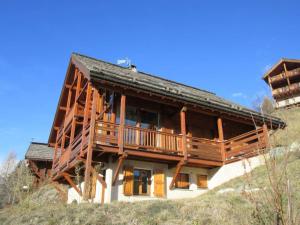 Cette grande maison en bois dispose d'un balcon sur une colline. dans l'établissement Chalet Face aux Etoiles, à Molines-en-Queyras