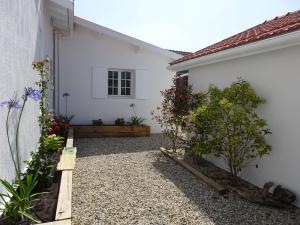 un patio de una casa blanca con jardín en 23 en Soulac-sur-Mer
