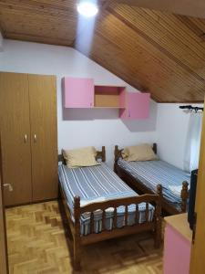 two twin beds in a room with wooden ceilings at IS Guest House in Ohrid