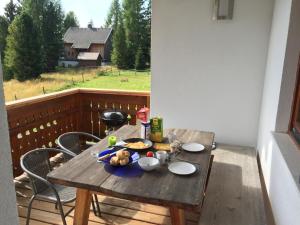a wooden table with food on top of a balcony at Almvilla Hochrindl in Hochrindl +17 photos