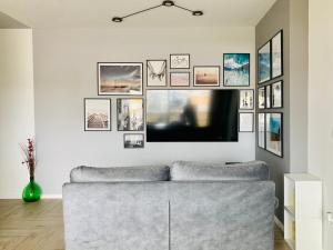 un soggiorno con divano e immagini appese al muro di UPLÈ family bike apartment a Lecce