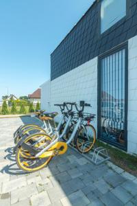 two bikes are parked next to a building at Summer House-Nowoczesne domki z jacuzzi i ładowarką do samochodu in Wrzosowo