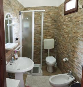 een badkamer met een toilet, een wastafel en een douche bij Casa Vacanze"Il Bouganville" in Carbonia