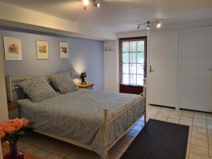 Schlafzimmer mit einem Bett, einem Fenster und einer Tür in der Unterkunft Le Malpas Woodpecker in Belvès