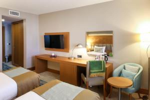 ein Hotelzimmer mit Schreibtisch, Computer und Bett in der Unterkunft SYM Hôtel in Cheraga + 8 Fotos