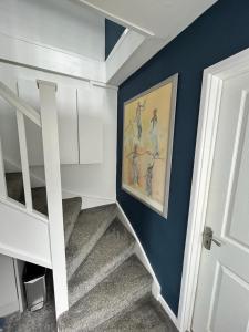 una escalera con una pintura de aves en una pared azul en Godrevy Lighthouse View, Carbis Bay, St Ives, free parking near beach, en Carbis Bay